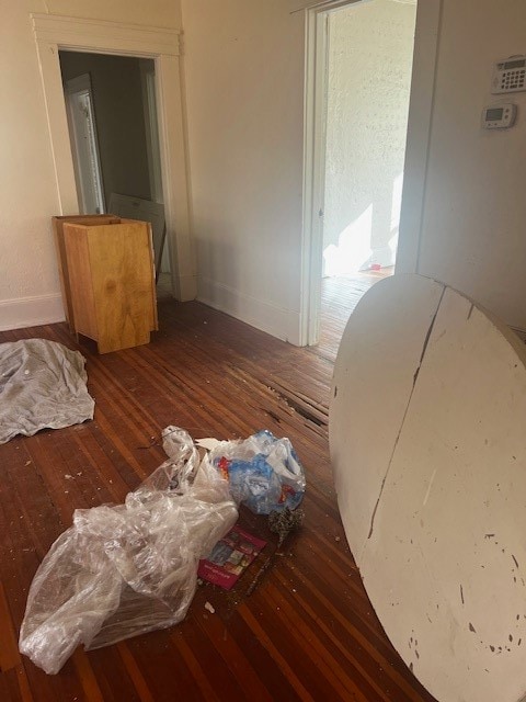 Bedroom with dark wood finished floors and baseboards