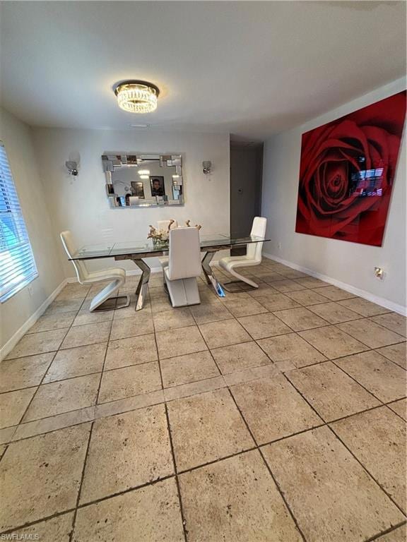 Unfurnished dining area with baseboards and tile p