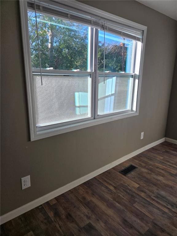Unfurnished room featuring dark wood finished floo
