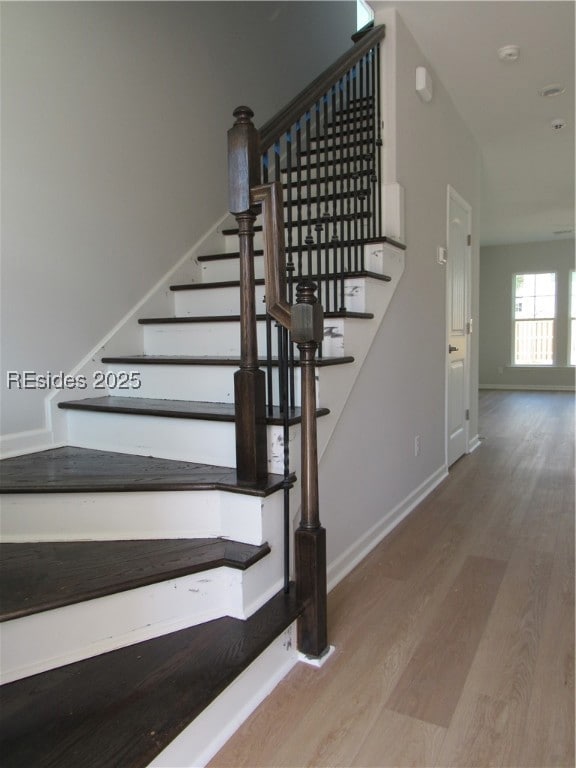 foyer features oak stairs and wrought iron railing