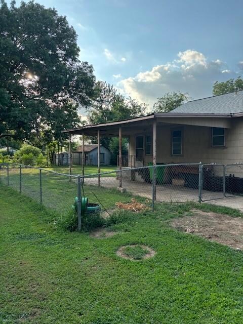 View of covered carport and fenced backyard.