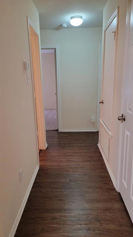 Hall featuring baseboards and dark wood-style flo