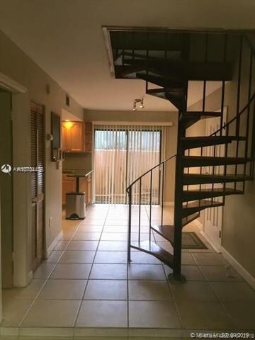 From living room area to dining and kitchen area with spiral staircase to second floor.