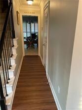 Corridor featuring ornamental molding, dark wood finished floors, and stairs