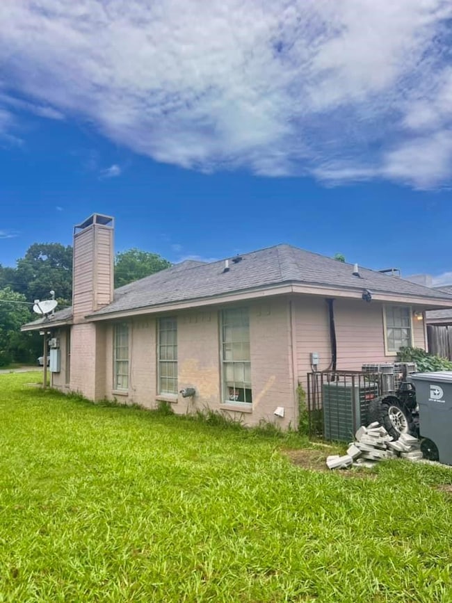 Back of house with a yard and a chimney
