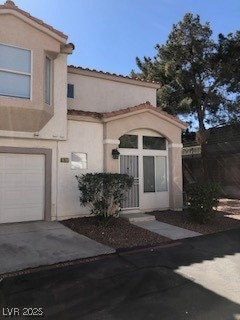 View of exterior entry featuring a garage, concret