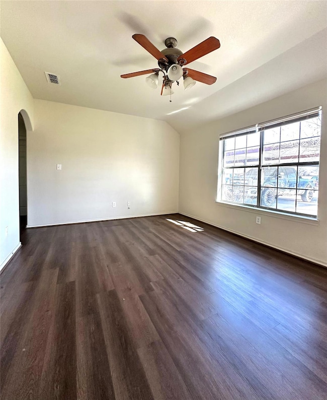 Empty room with lofted ceiling, visible vents, arc