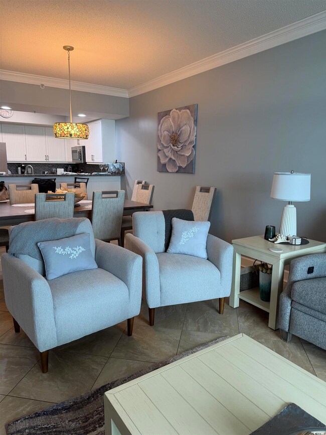 Tiled living area featuring ornamental molding and a textured ceiling