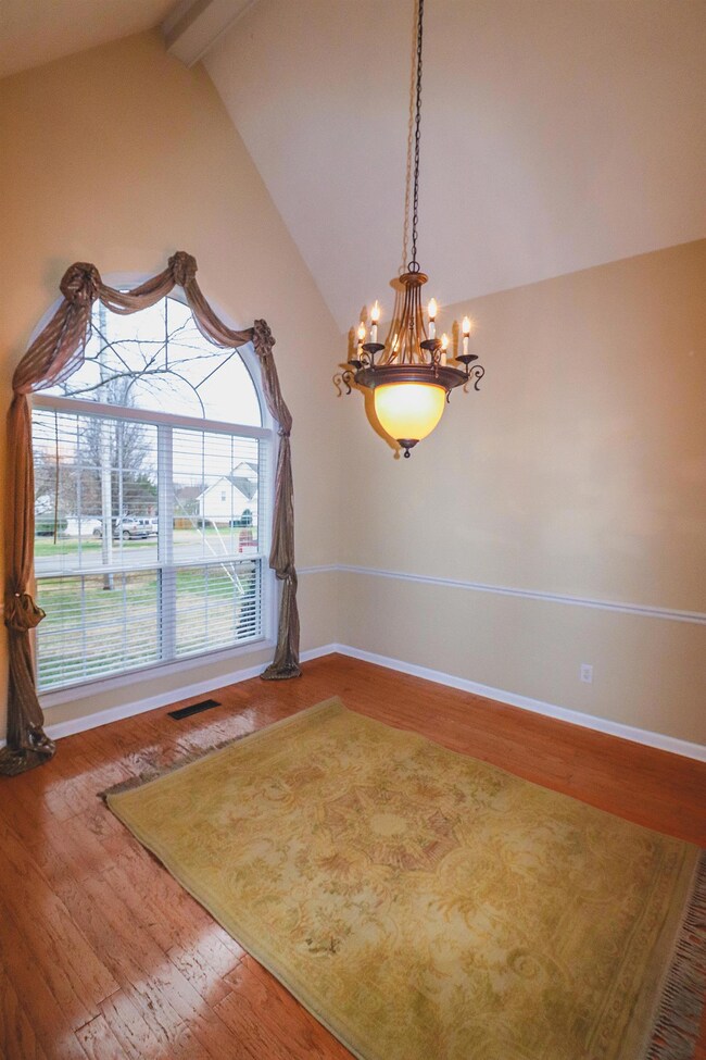 Gorgeous dining room with vaulted ceilings, plantation blinds and real hardwood flooring. 