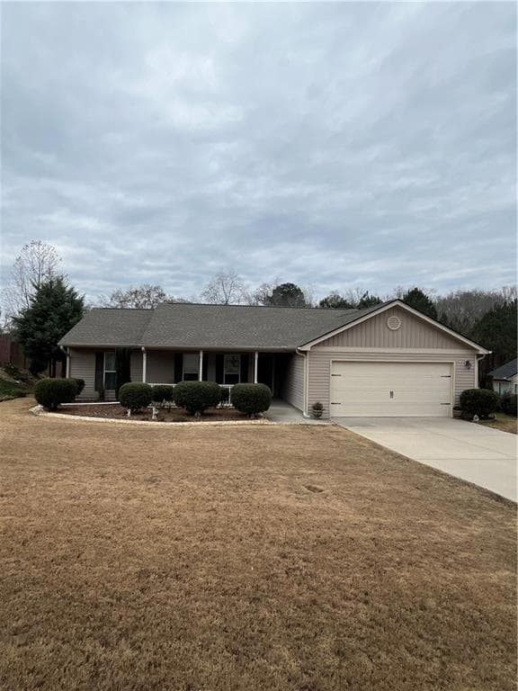 Ranch-style home with a garage, driveway, and a fr