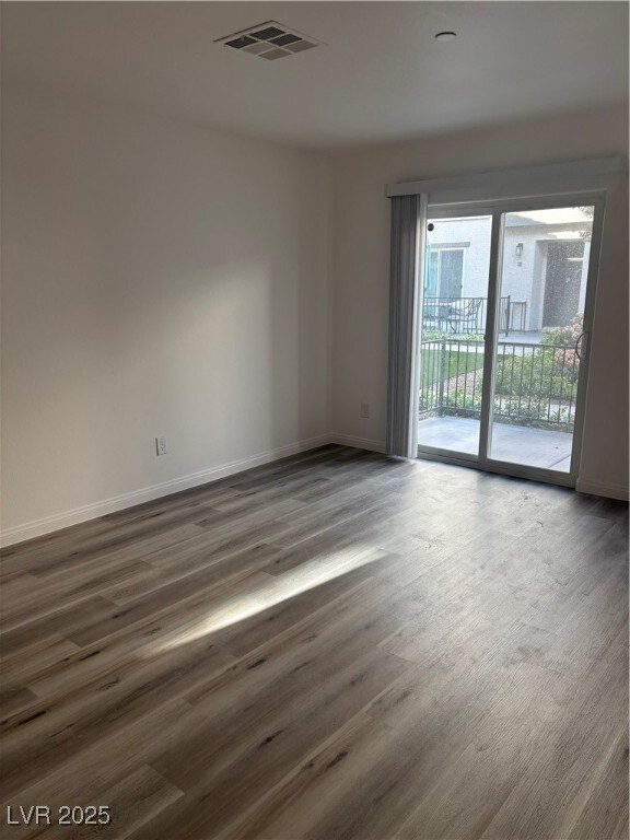 Empty room with visible vents, baseboards, and dar