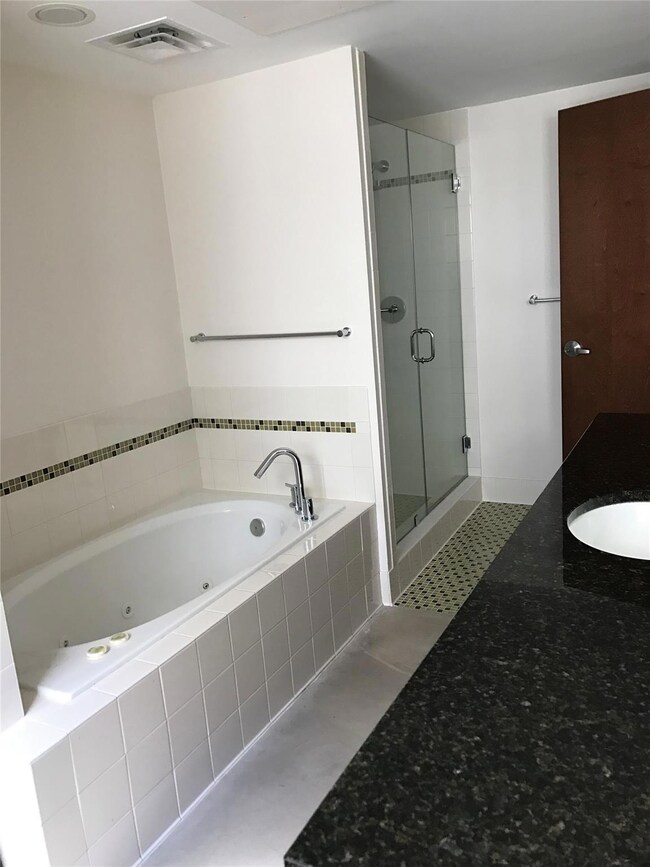 Bathroom featuring visible vents, a tub with jets