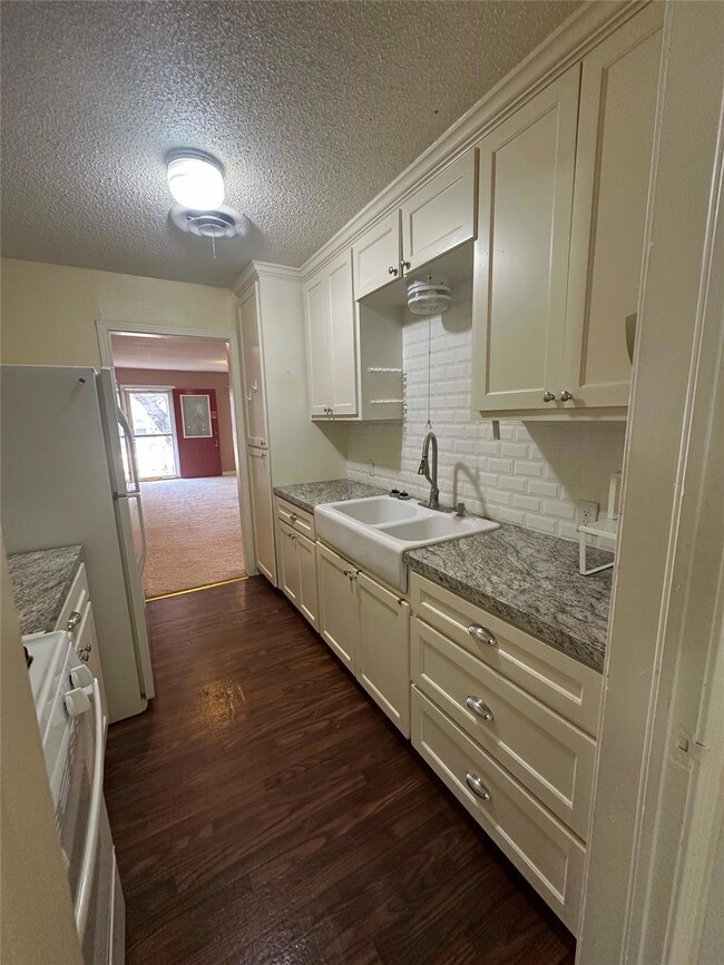 Kitchen with white appliances, sink, dark hardwood