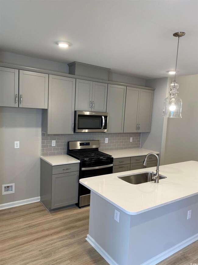 Kitchen with backsplash, sink, light hardwood / wo