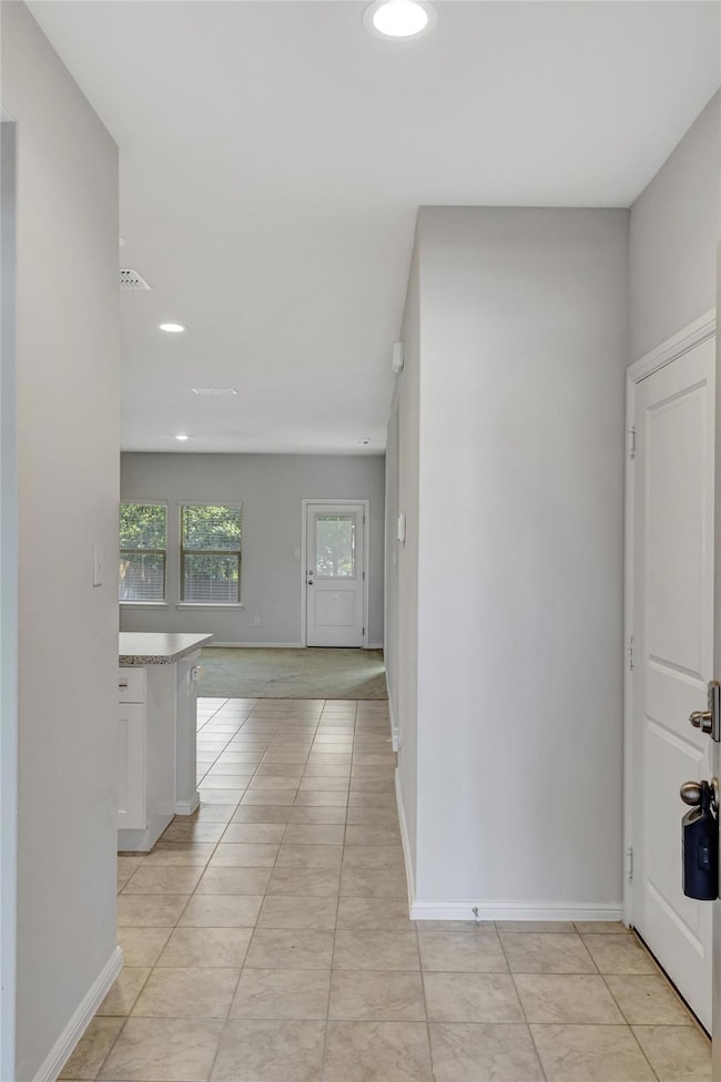 Hallway featuring light tile patterned floors