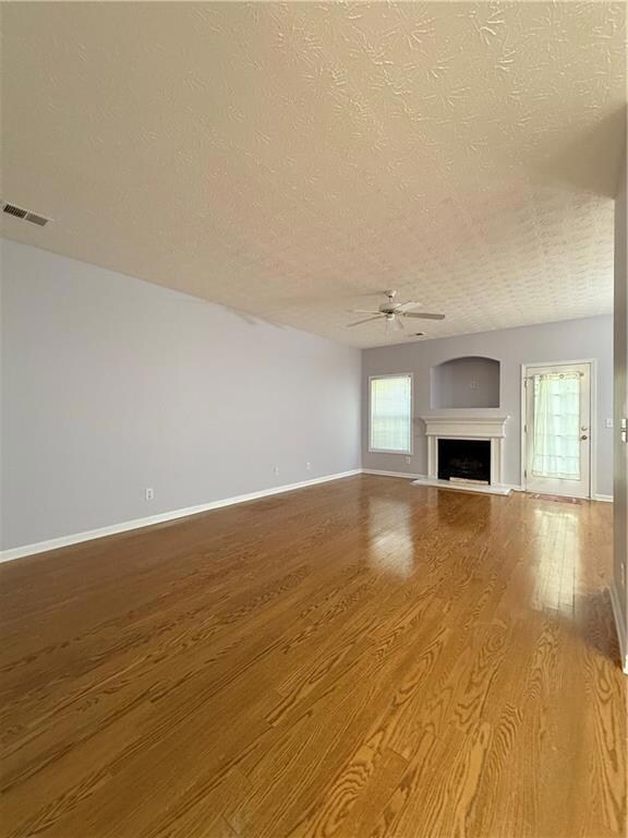 Unfurnished living room featuring visible vents, b