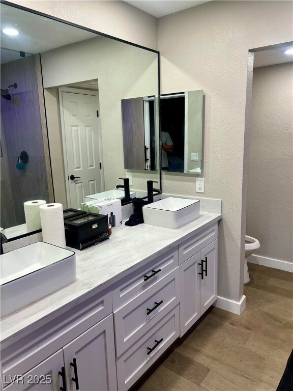 Full bathroom featuring a sink, a shower stall, wo