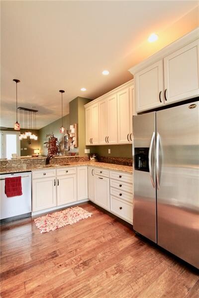Kitchen features stainless steel appliances, wood floors and granite countertops.