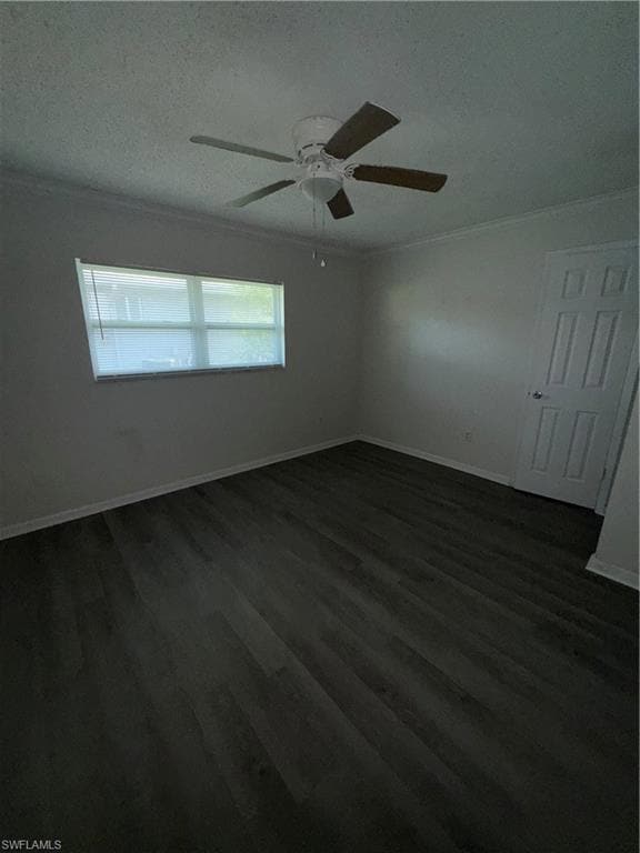 Empty room featuring dark wood-style floors, a textured ceiling, ornamental molding, and ceiling fan