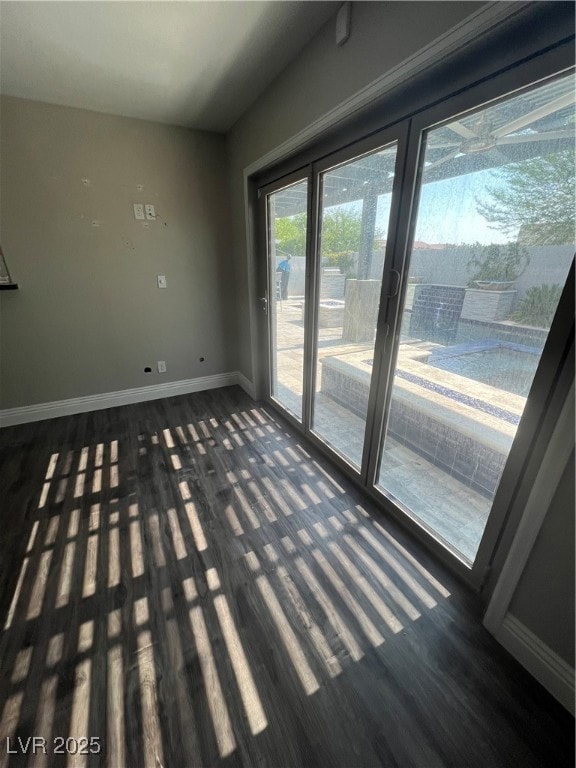 Spare room with baseboards and wood finished floor