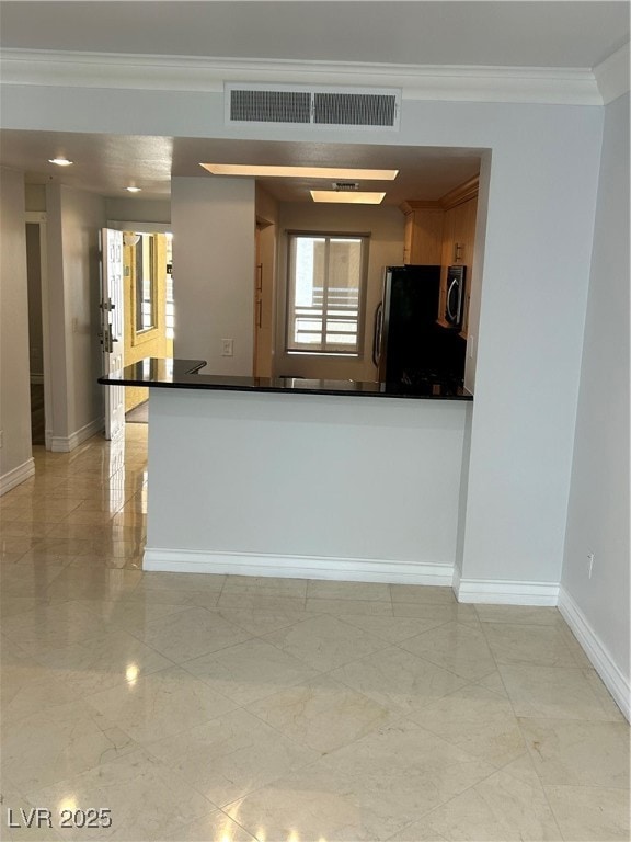 Kitchen featuring fridge, crown molding, light mar