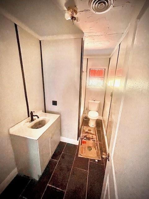 Bathroom featuring vanity, toilet, and tile patter
