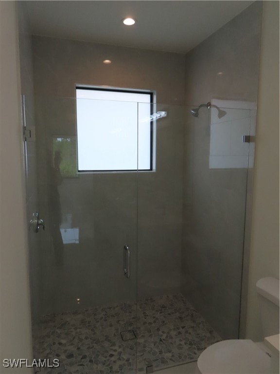 Bathroom featuring a shower stall and recessed lig