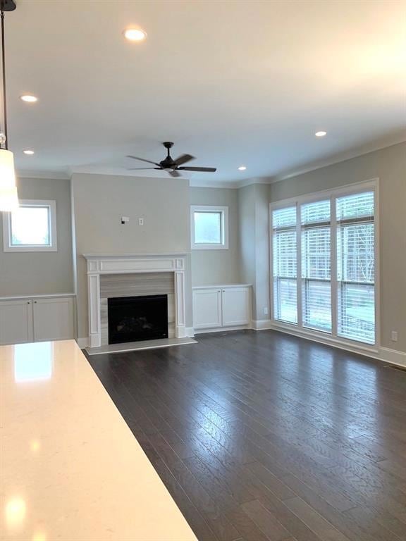 Unfurnished living room featuring a ceiling fan, d