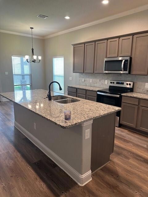 Kitchen featuring a center island with sink, dark hardwood / wood-style flooring, tasteful backsplash, and range
