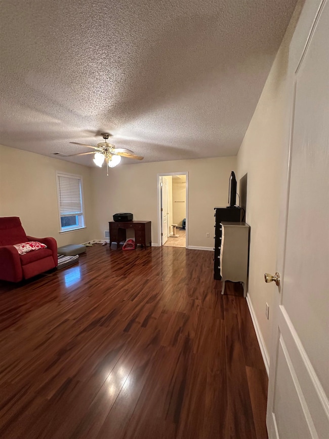 Unfurnished living room featuring dark wood-type f