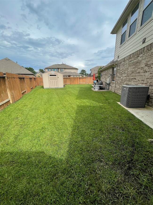 Entry to left side yard with custom painted shed to match the house.