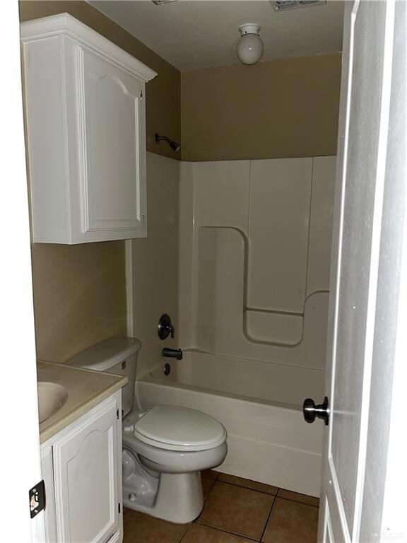 Bathroom with visible vents, toilet, vanity, shower / bath combination, and tile patterned flooring