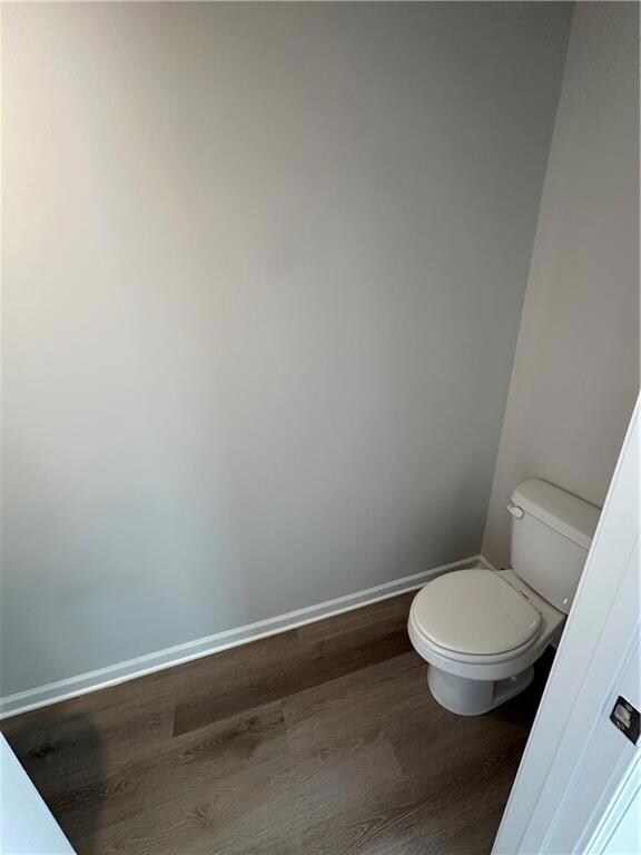 Bathroom with baseboards, toilet, and wood finishe