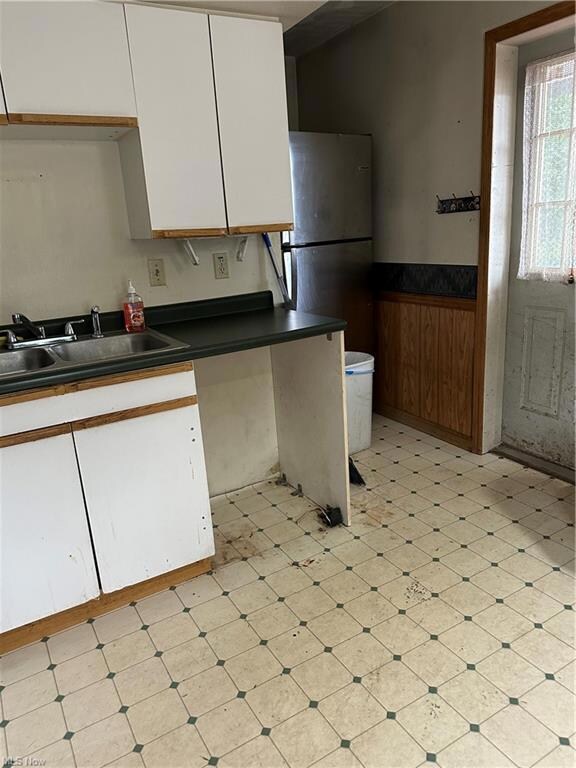 Kitchen featuring light tile flooring, white cabin