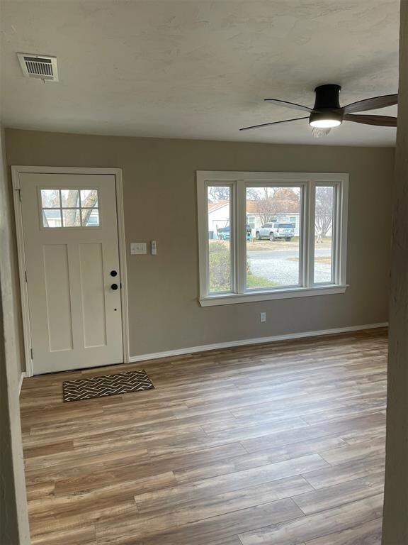 Foyer with ceiling fan, light wood-type flooring, 