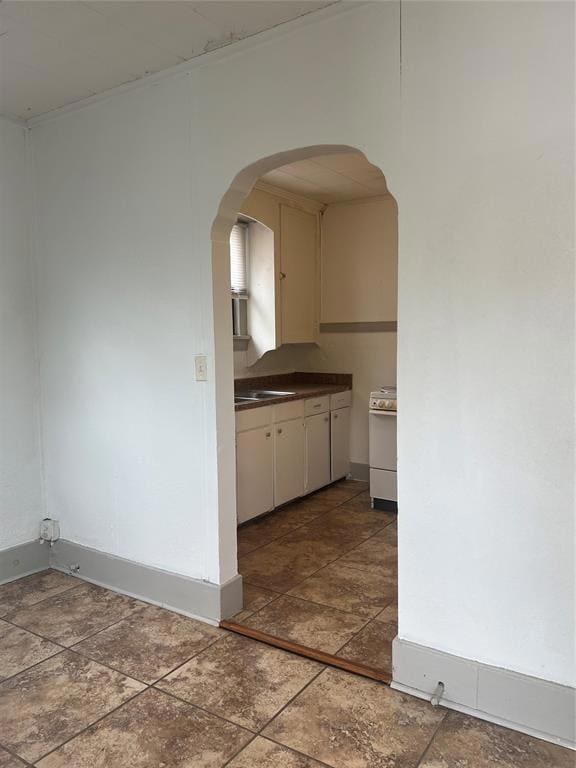 Kitchen featuring dark countertops, arched walkway