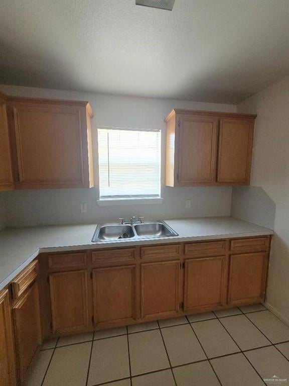 Kitchen featuring light tile patterned flooring, sink, and a textured ceiling
