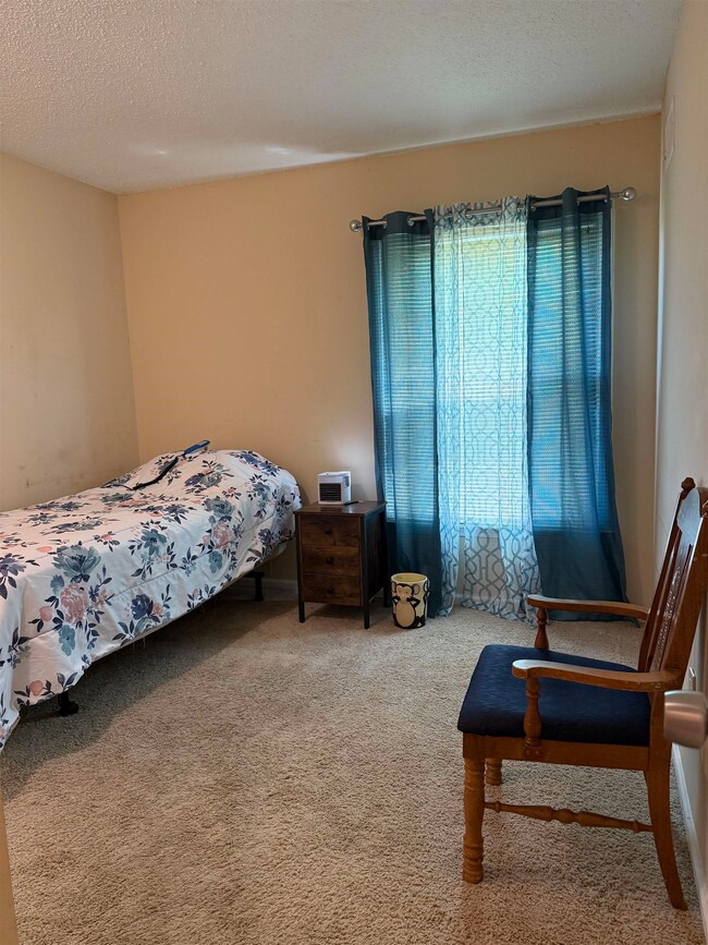 Carpeted bedroom featuring a textured ceiling