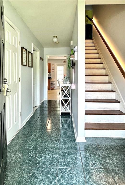 Stairs featuring tile patterned flooring and baseboards