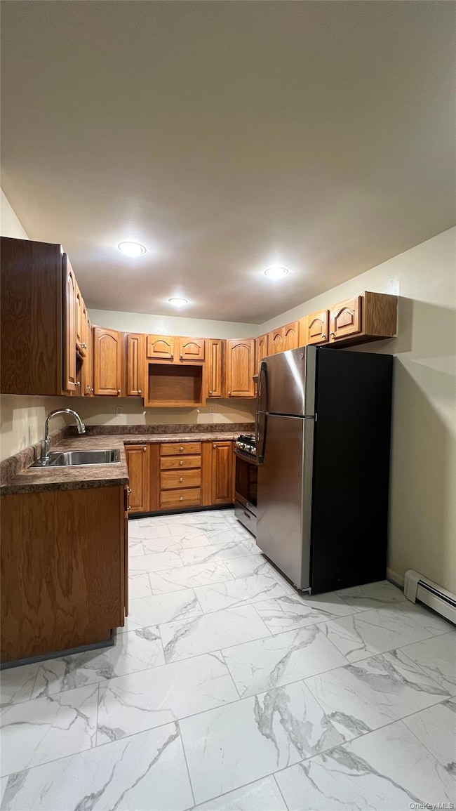 Kitchen featuring appliances with stainless steel finishes, dark countertops, light marble finish flooring, brown cabinets, and recessed lighting