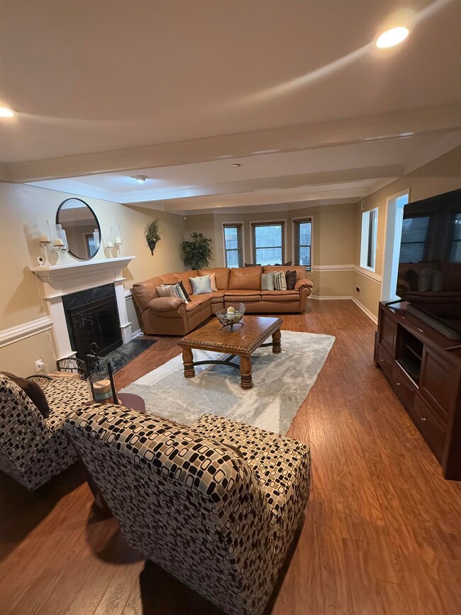 Living area with beamed ceiling, a fireplace, wood