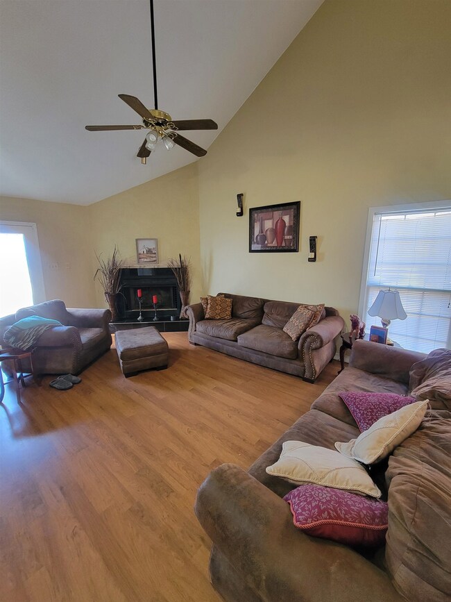 Living room with high vaulted ceiling, light wood-