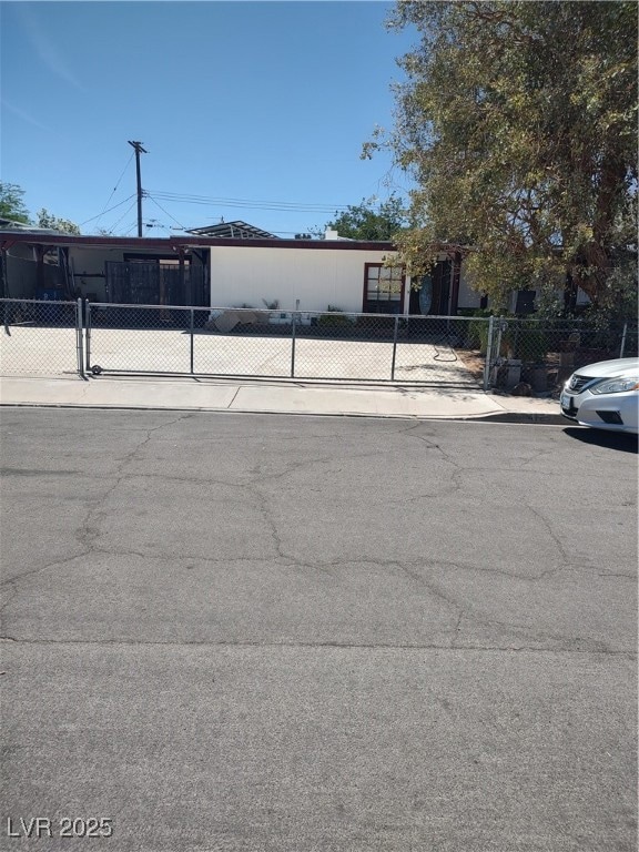 View of front exterior with large driveway & gated