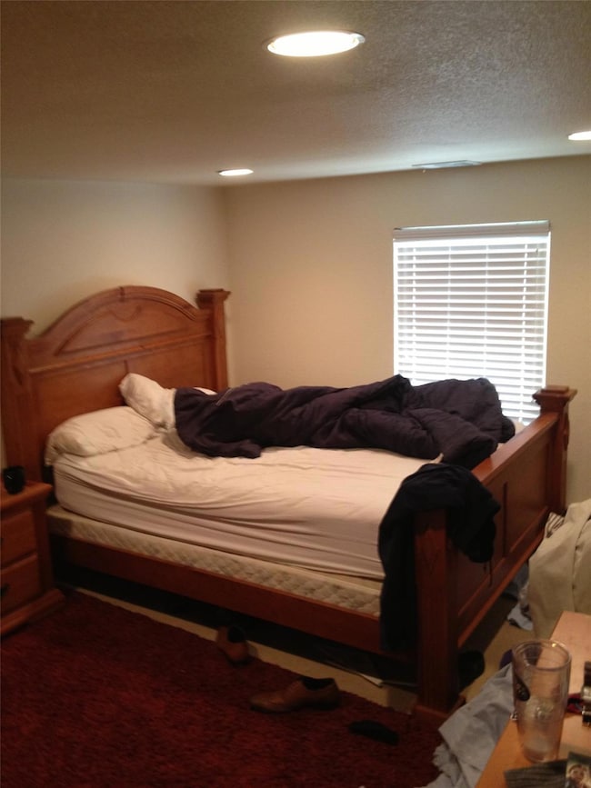 Carpeted bedroom with recessed lighting and a textured ceiling
