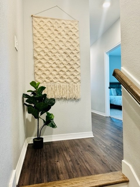 Corridor featuring wood finished floors and basebo