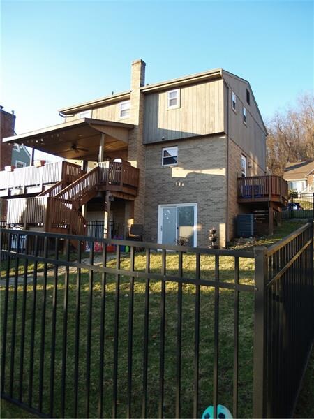 Fenced-In back yard with view of side deck off kit