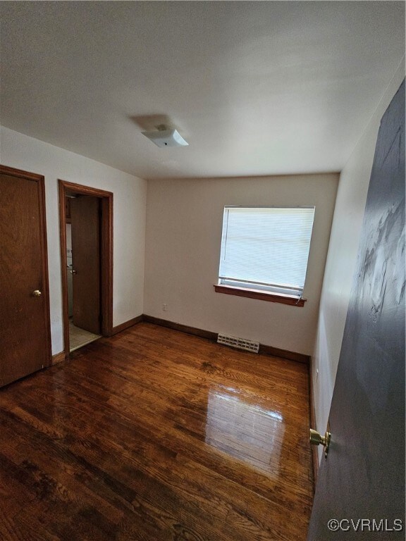 Unfurnished bedroom with dark hardwood / wood-style flooring and a textured ceiling