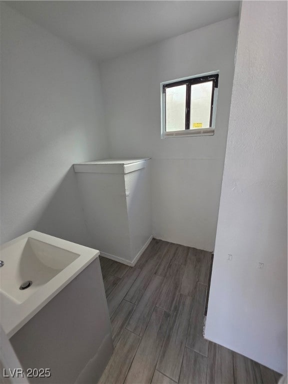 Laundry area featuring wood tiled floors and a sink