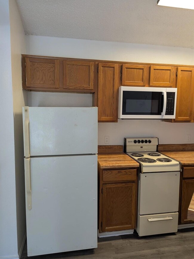 Kitchen with light countertops, white appliances, 