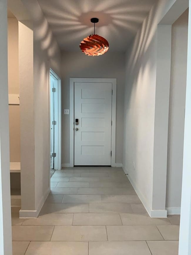 Hallway featuring light tile patterned flooring a